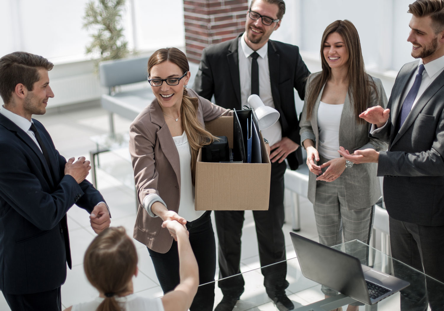 Business woman holding moving box with office supplies in it