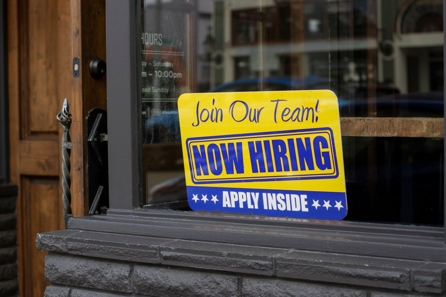 storefront with now hiring sign