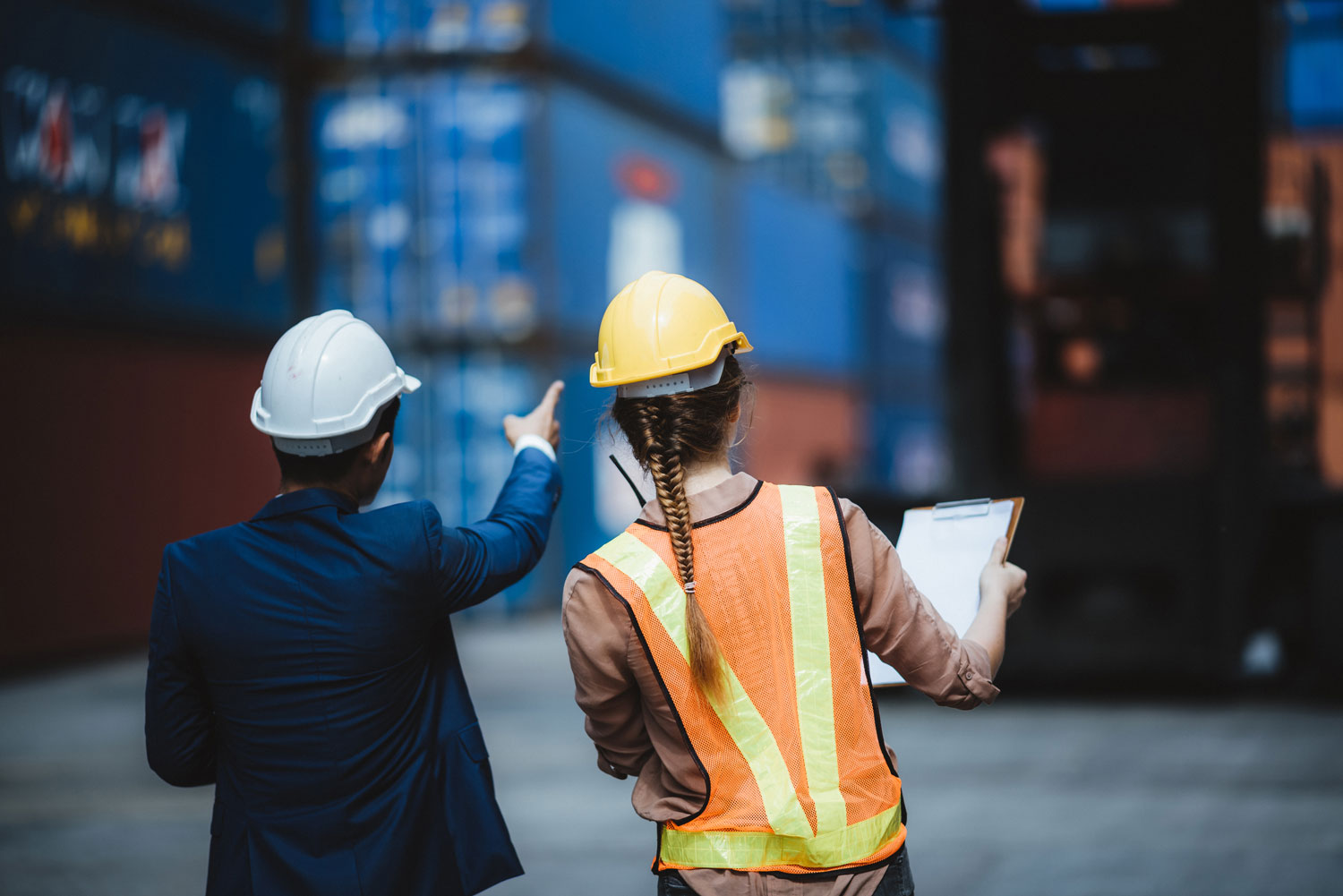 two men pointing at shipping containers